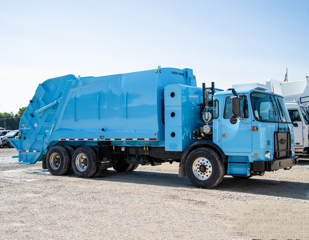 A blue Autocar ACX severe duty rear-end loader truck with power of one integration.