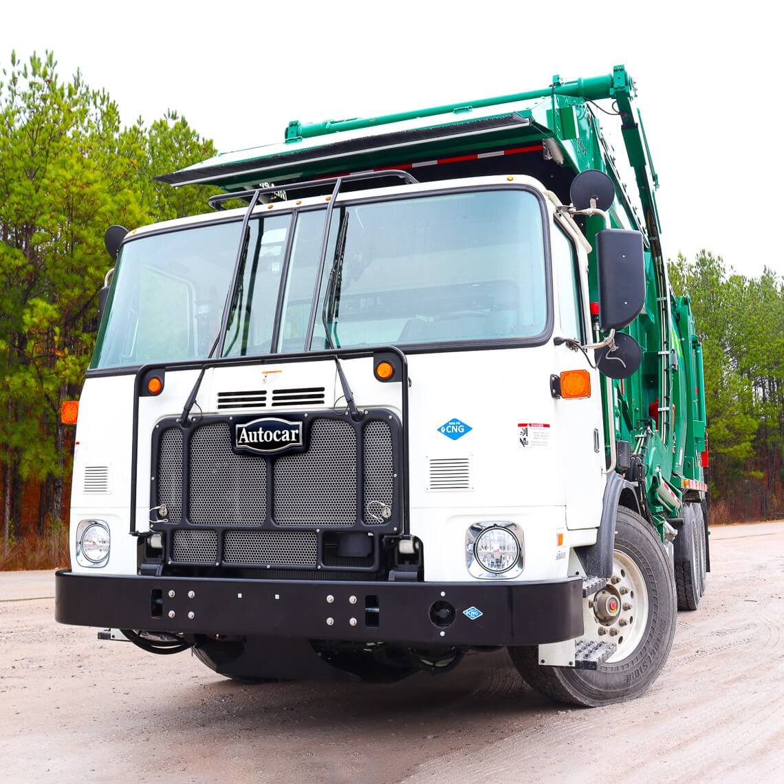 The ACX severe duty front-end loader with green body parked on a dirt road. 