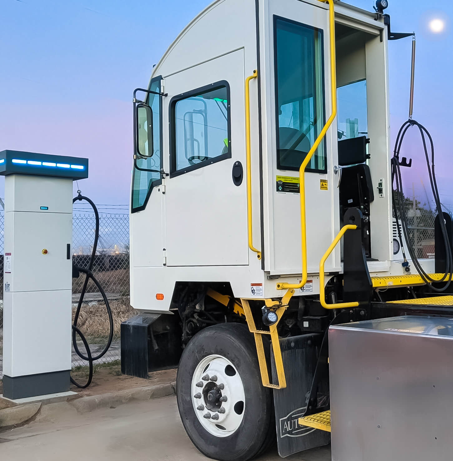 The Autocar E-ACTT all-electric terminal tractor at a charging station.